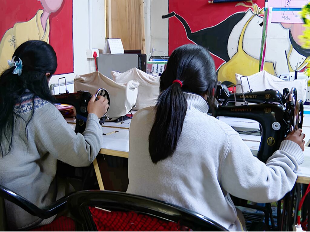 Young people taking part in a sewing and skills activity at Nazhoen Lamtoen.