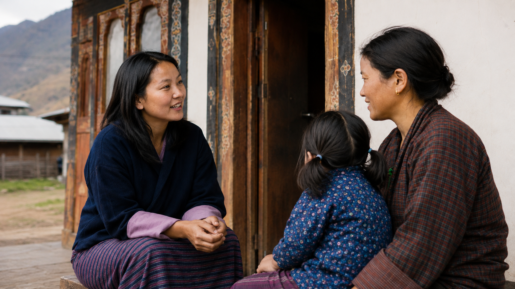 Bhutanese staff member speaking with a mother and child outside a traditional home - placeholder