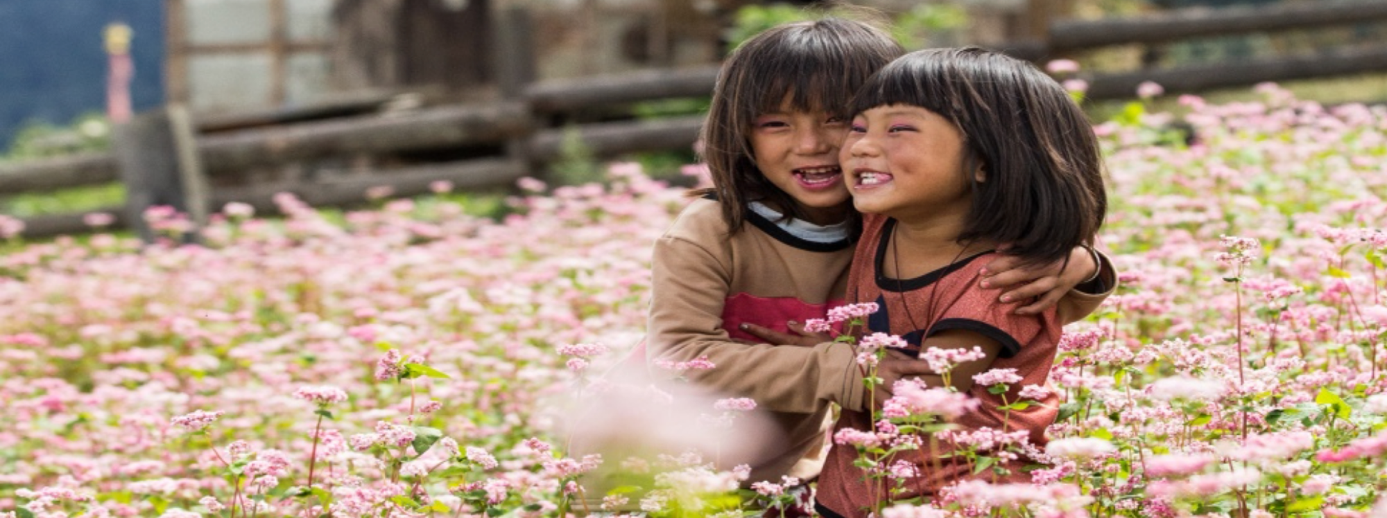 Smiling Bhutanese girls standing in a field of flowers